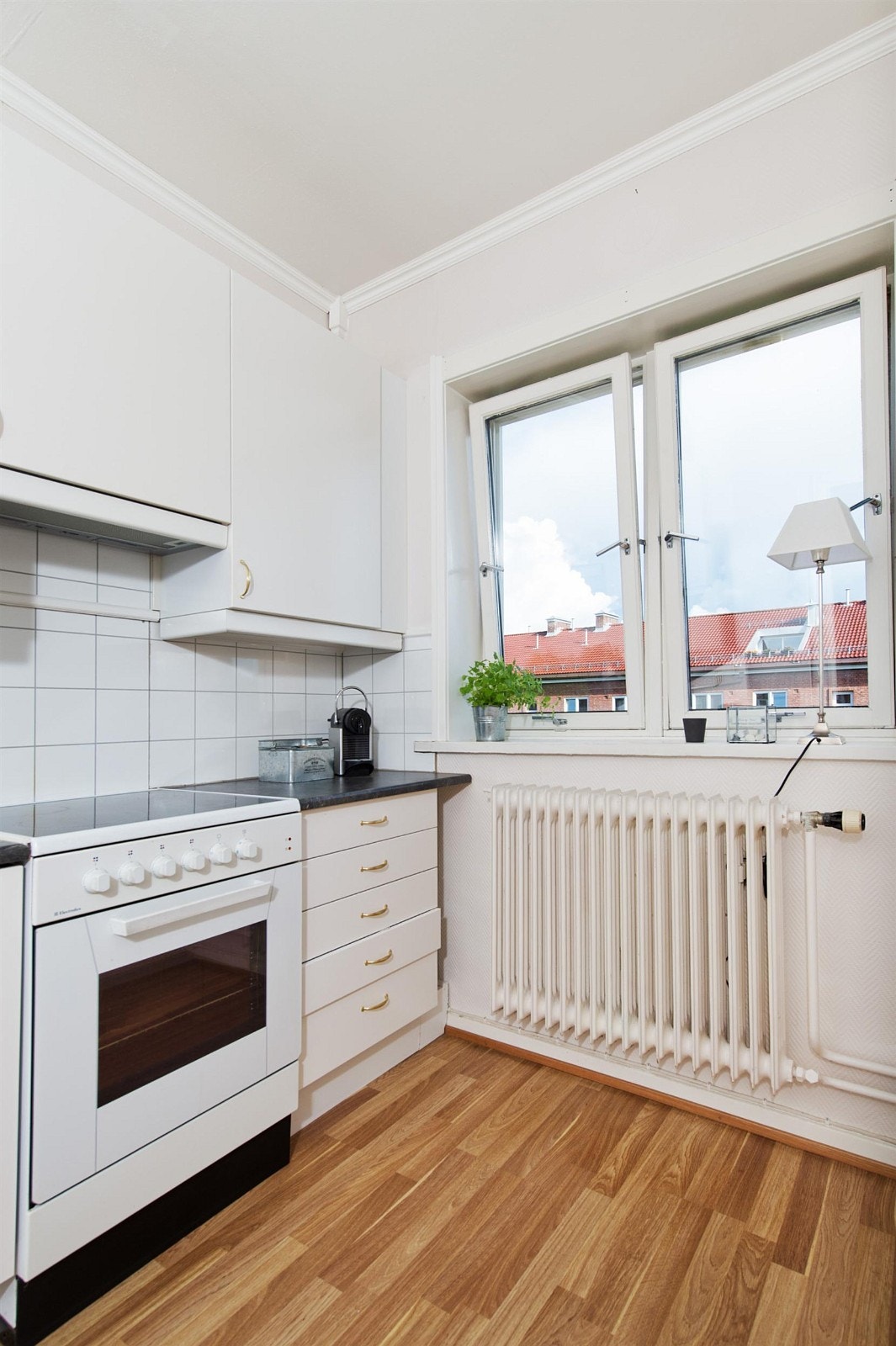 Kjøkken med vindu ut til hyggelig bakgård Galleribilde