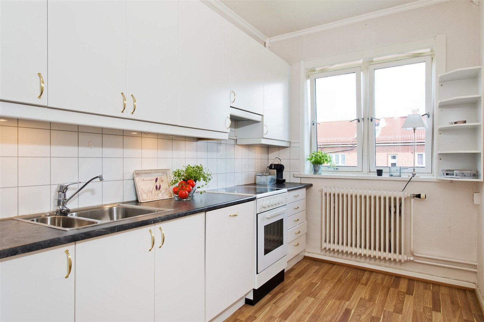 Pent kjøkken med lyse flater og god benkeplass for tilberedning av mat Galleribilde