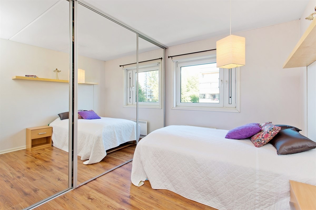 Romslig soverom med stor skyvedørsgarderobe med speilfronter Galleribilde