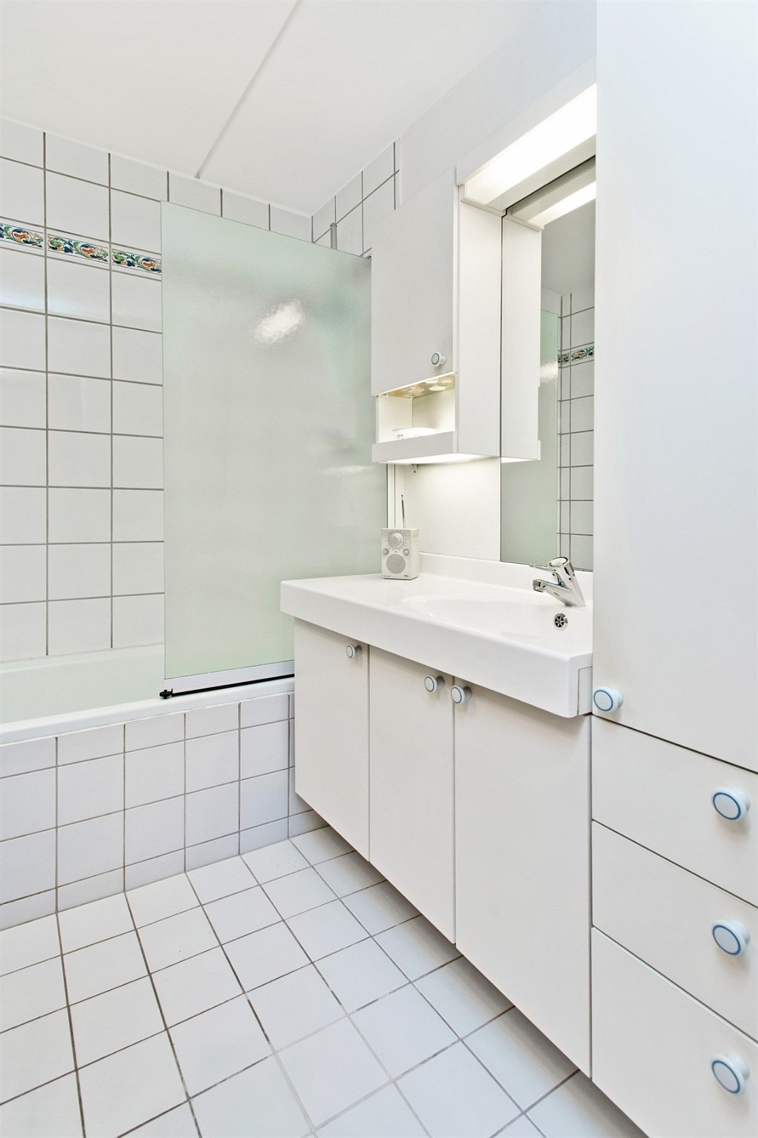 Pent flislagt bad med innmurt badekar og varmekabler. Galleribilde