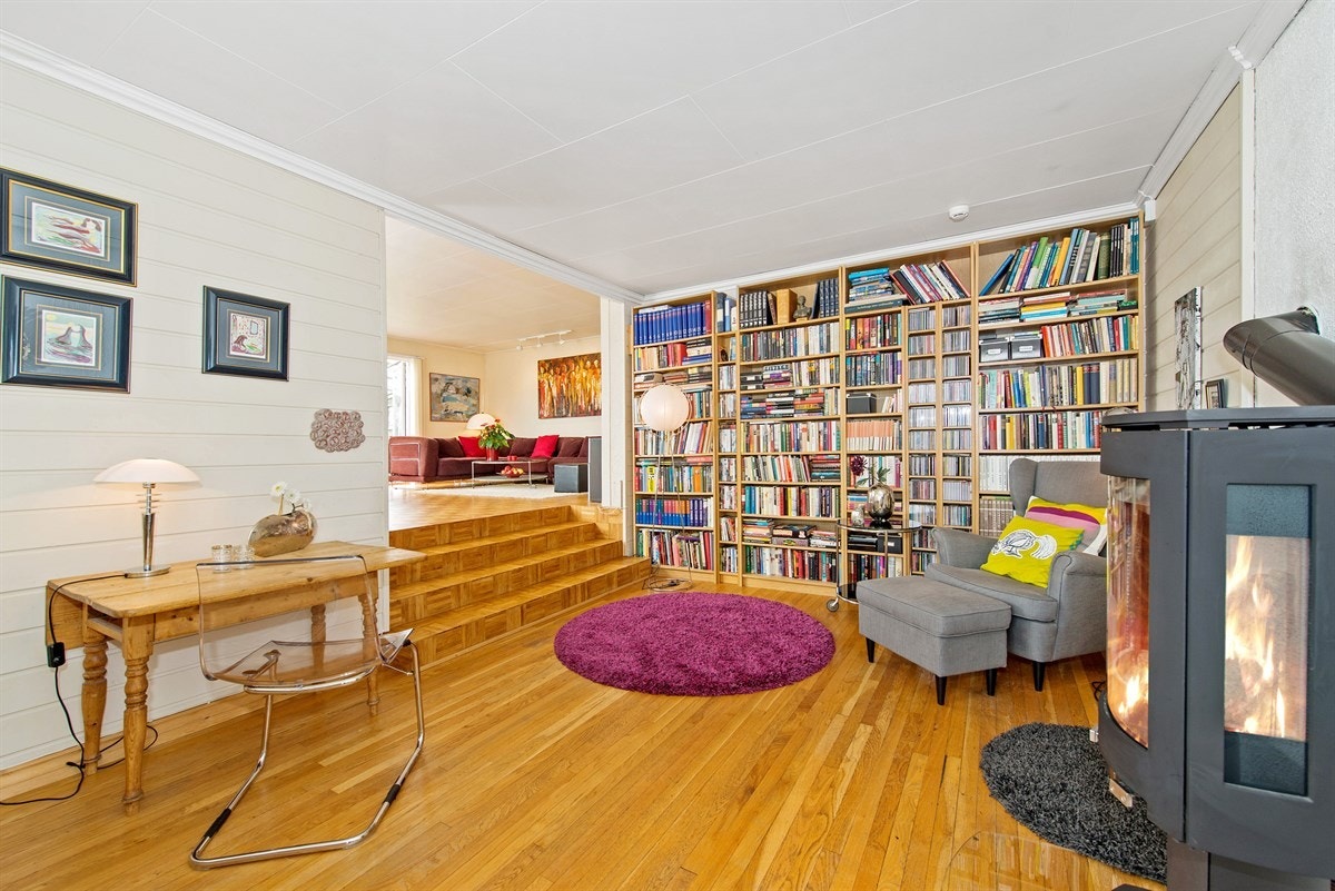 Peisestue/bibliotek med trapp opp til hovestua Galleribilde