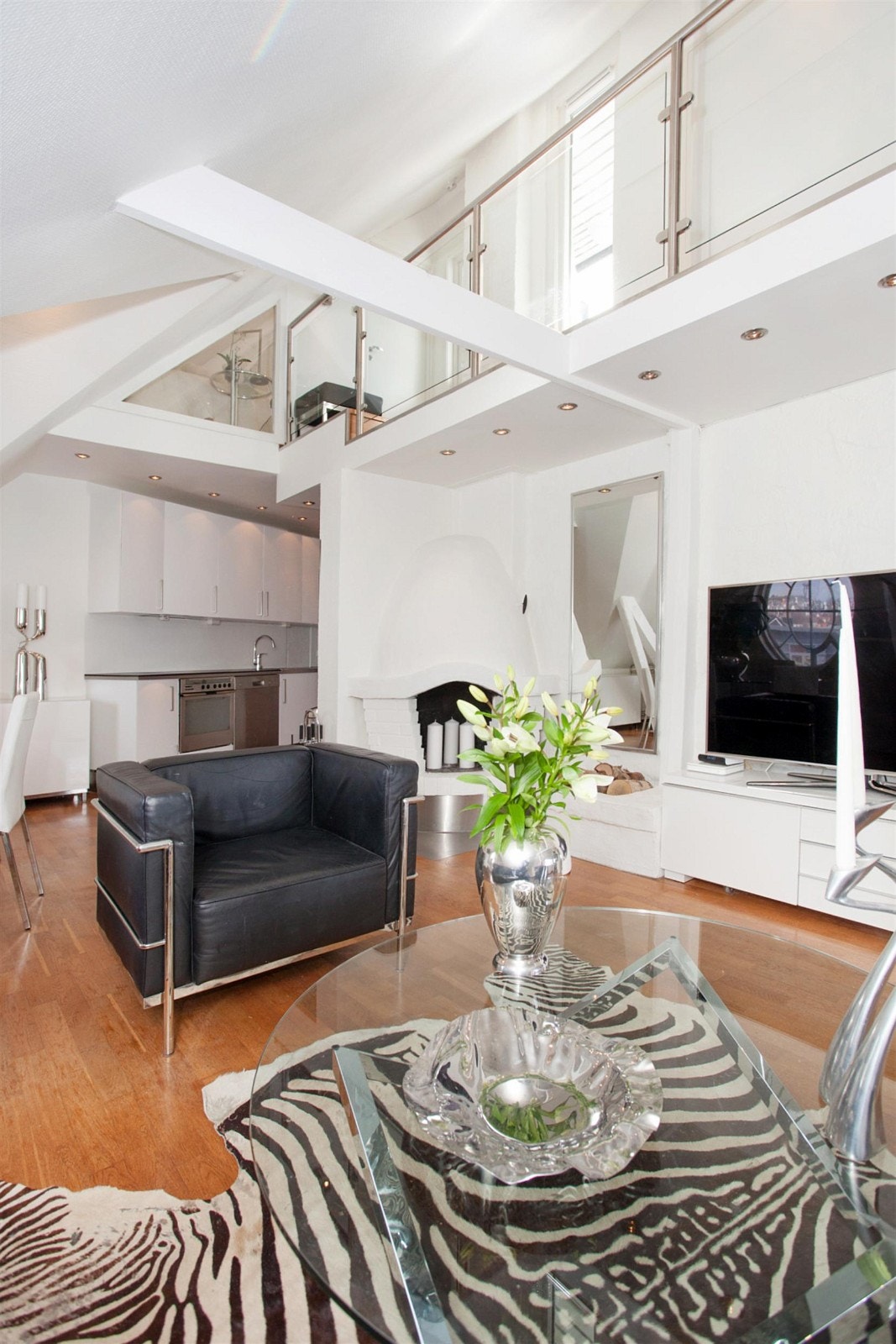 Stue med skråtak, downlights og peis. Galleribilde