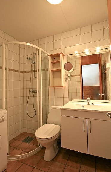 bad med toalett, vask, dusj og opplegg for vaskemaskin Galleribilde