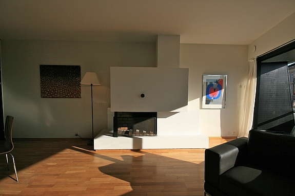 stua har glassfasade mot balkongen og peis Galleribilde