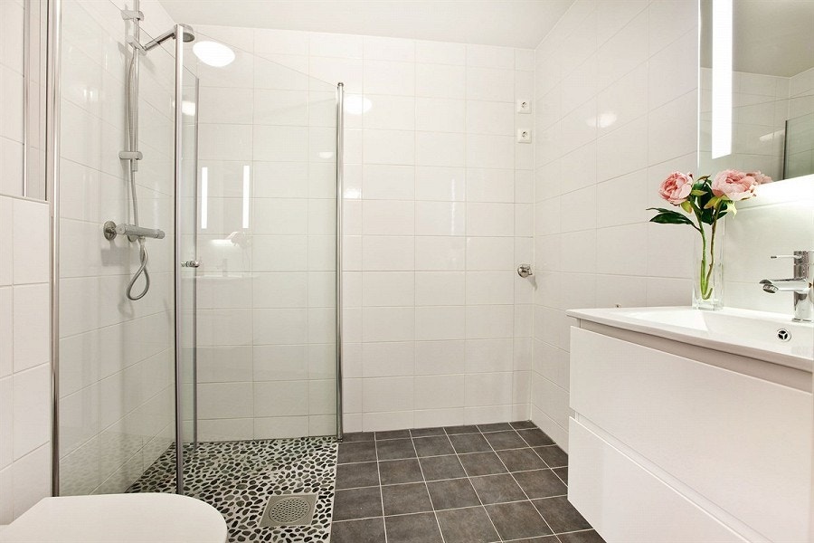 Bad med vegghengt toalett, dusj hjørne og opplegg for vaskemaskin Galleribilde