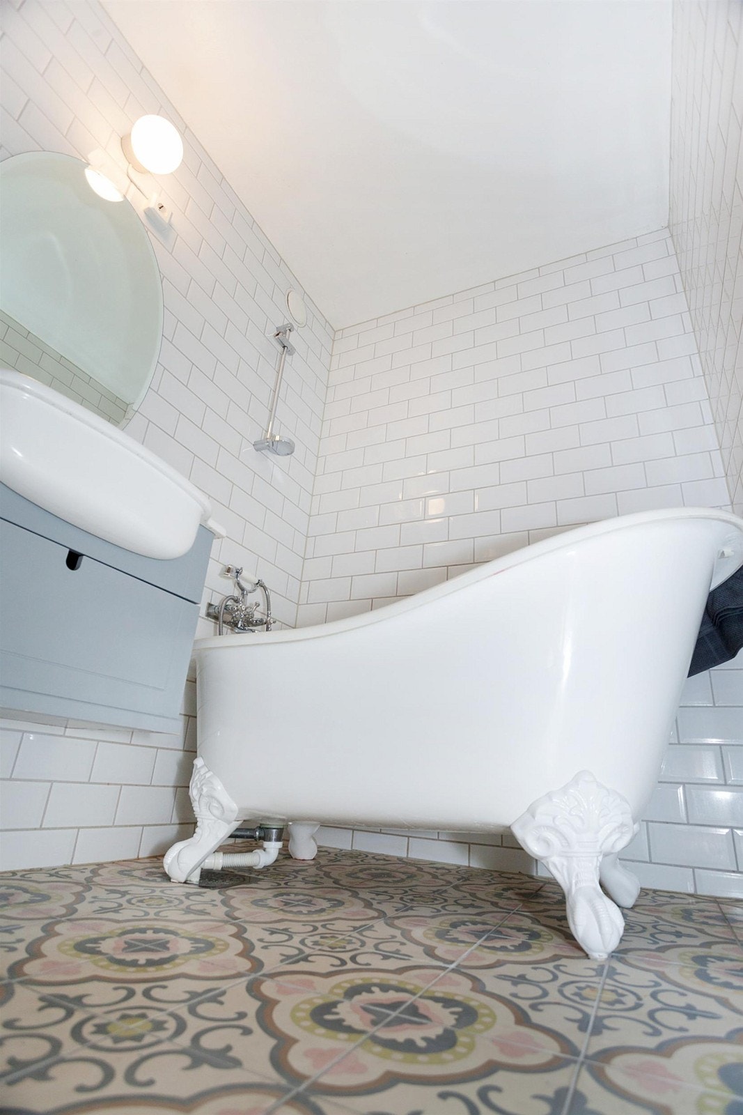 Flislagt bad med dusj på vegg, badekar og servant. Galleribilde