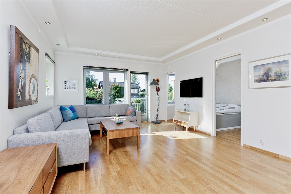 Lys og innbydende stue med downlights i tak og adkomst til vestvendt balkong. Galleribilde