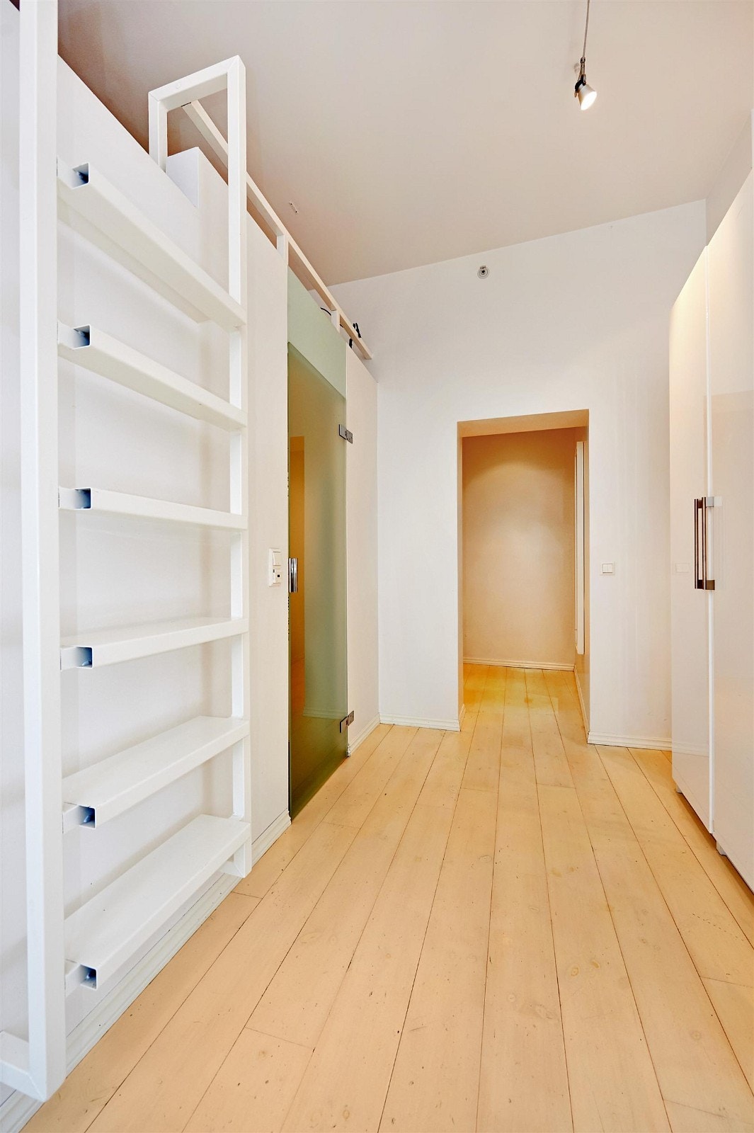 Adkomst til sovehemsen. Kul baderomsdør i glass skimtes ved siden av trinnene opp til hemsen. Galleribilde