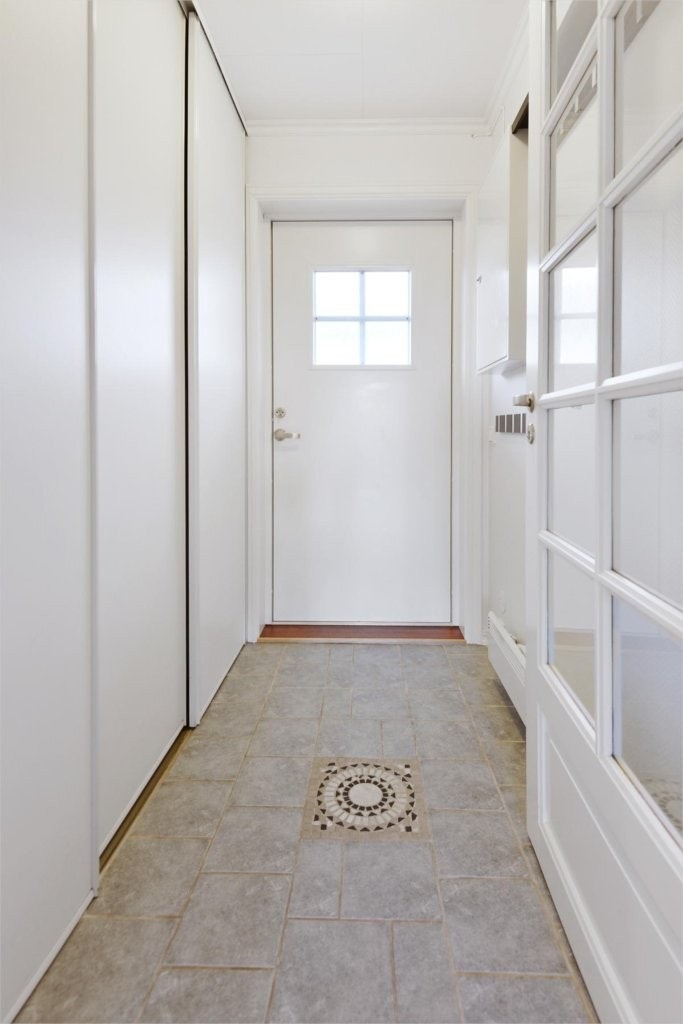 Entré/Inngangsparti med skyvedørsgarderobe og fliser på gulv. Knagger til yttertøy montert under sikringsskap -lettvint for de små. Galleribilde
