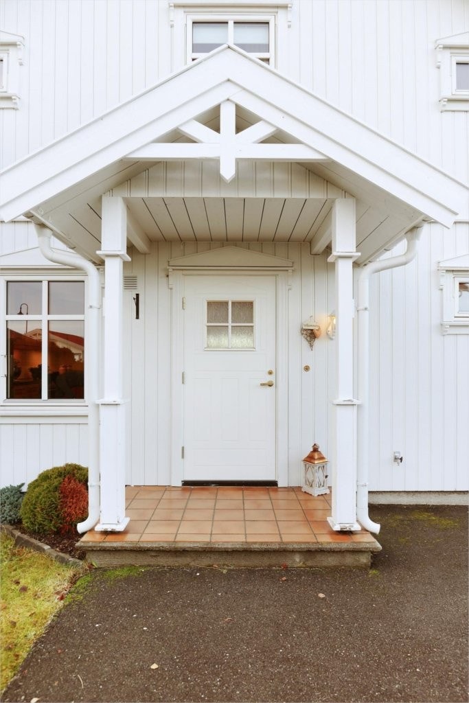 Overbygget inngangsparti med fliser på trappeavsats. Galleribilde