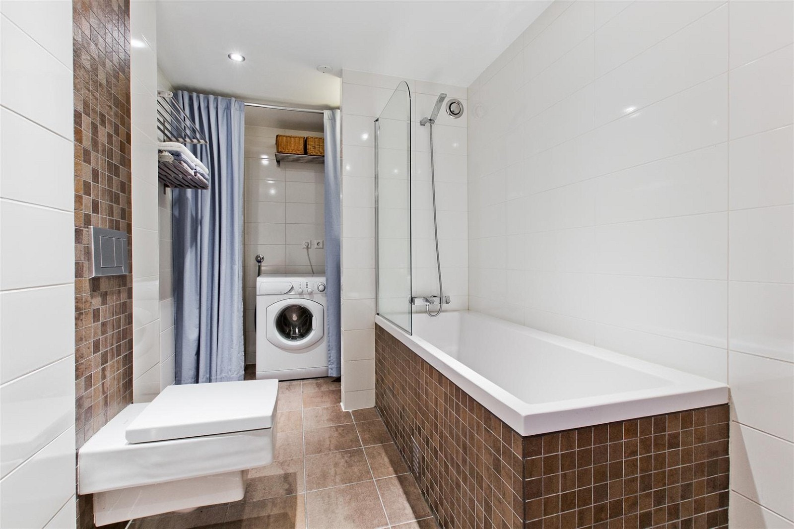 Lekkert og påkostet flislagt bad som er renovert i 2011/2012. Veggmontert wc med skjult sisterne, inkledd flislagt badekar og servantinnredning med heldekkende servant. Opplegg for vaskemaskin. Galleribilde