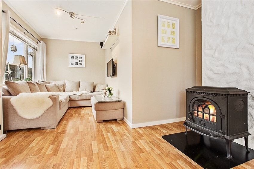 Stue i 1. etasje med laminat på gulv og lyse overflater på vegger og tak. Galleribilde