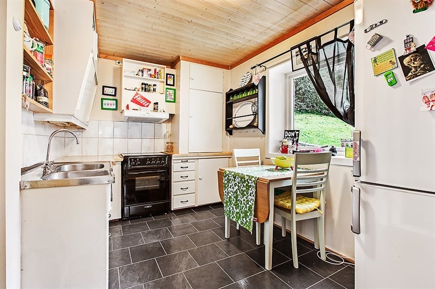 Kjøkken i underetasjen har slette malte fronter. Plass til spisebord på kjøkken. Galleribilde