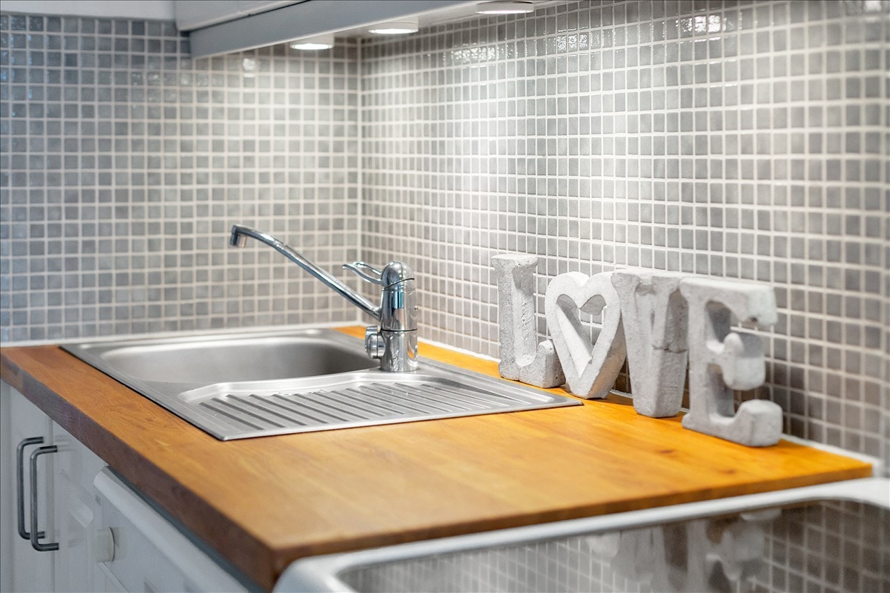 Heltre benkeplater, downlights under overskap og flotte mosaikkfliser over mellom over og underskap Galleribilde