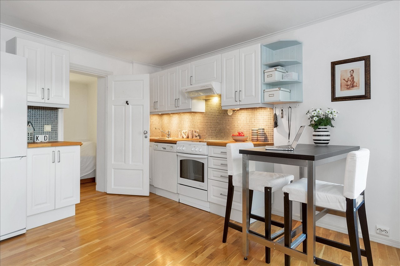 Lyst og moderne kjøkken som har rikelig med oppbevaringsplass og gode arbeidsflater. Galleribilde