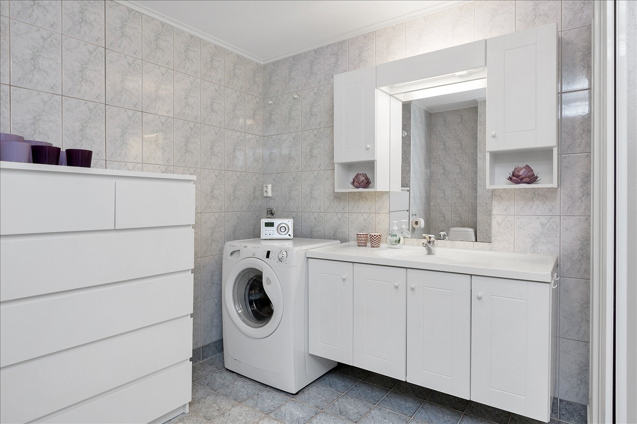 Romslig bad med innholdsrik baderomsinnredning og med opplegg til vaskemaskin. Galleribilde