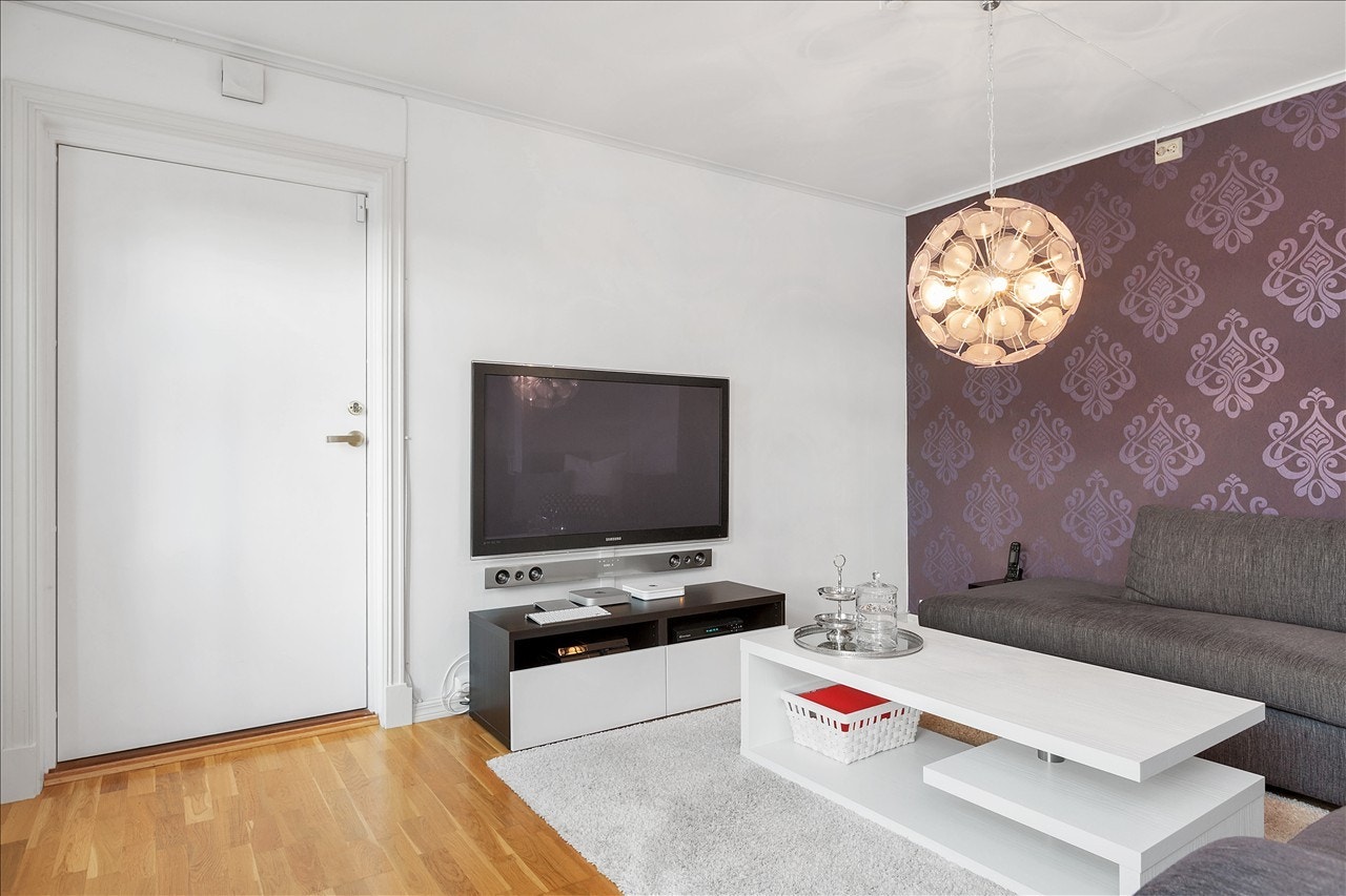 Flott kontrast tapet på vegg i stuen og profilerte lister rundt dører Galleribilde