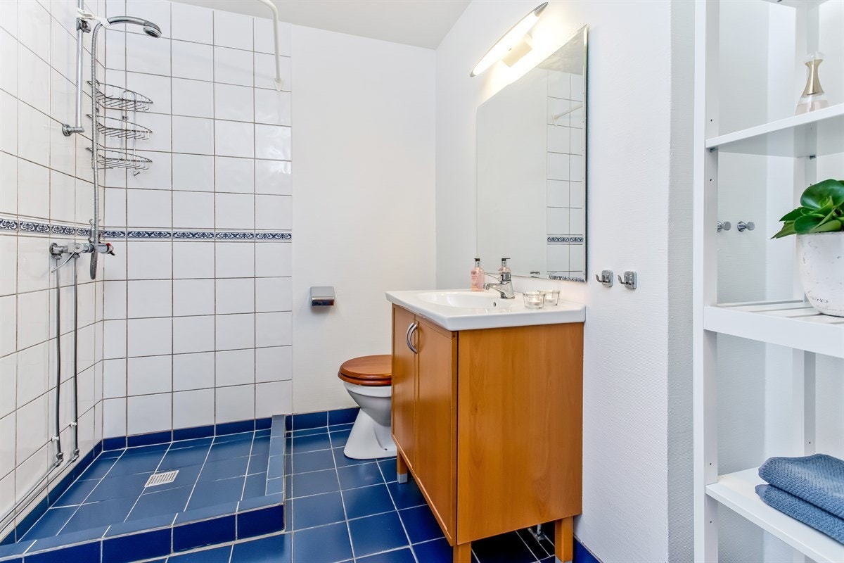 Delvis flislagt bad med dusjplass og opplegg for vaskemaskin Galleribilde