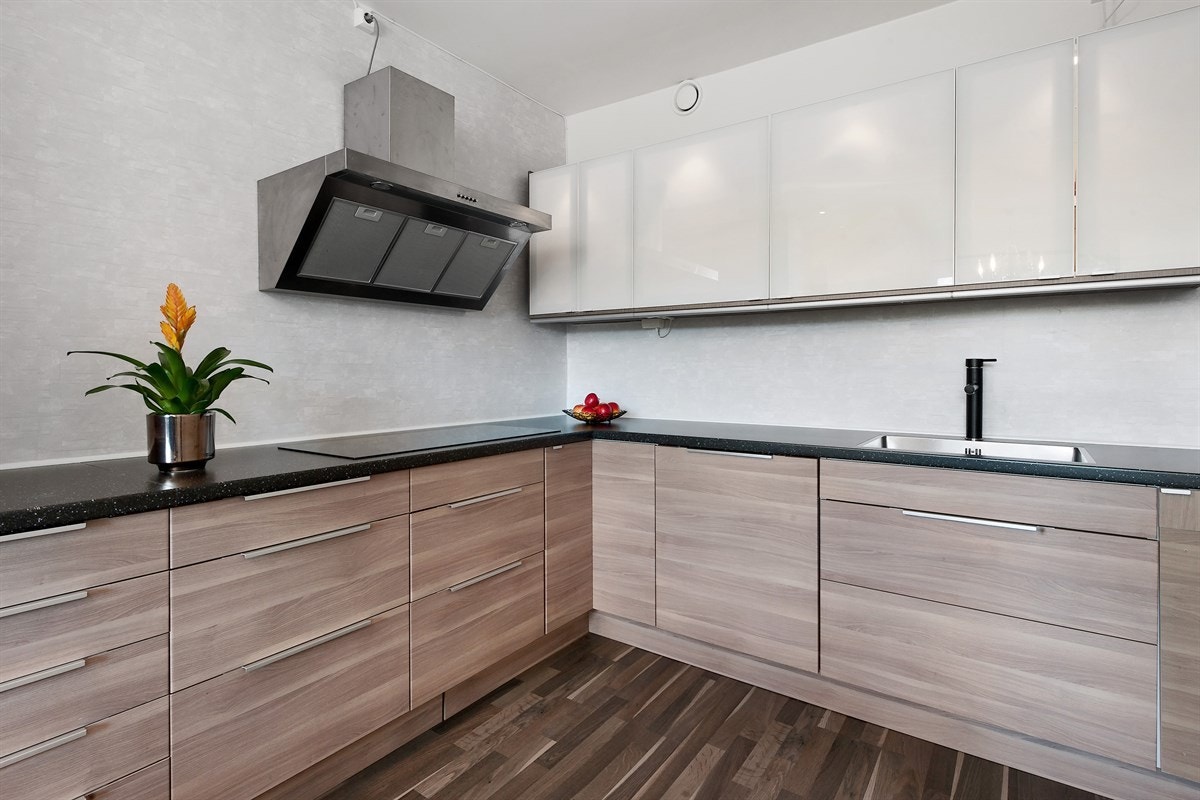 Kjøkkenet er utstyrt med benkebelysning, stekeovn, mikrobølgeovn, integrert kjøl/frys, ventilator i børstet stål og oppvaskmaskin. Rommet har pen laminat på gulv, spiseplass og utgang til solrik balkong. Galleribilde