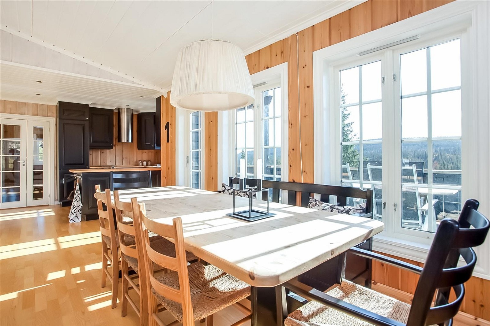 Stue og kjøkken i åpen løsning med god plass til langbord mellom stue- og kjøkkendel. Galleribilde