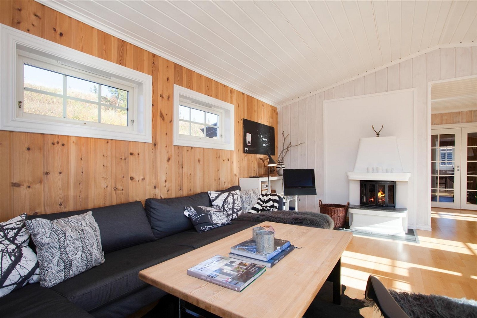 Åpen, hvitmalt himling og lysinnslipp på 3 sider gir en lys og trivelig stue. Galleribilde