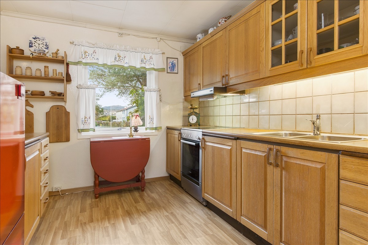 Praktisk kjøkken med godt med benkeplass. Ikke siste mote, men godt ivaretatt og fullt funksjonelt. Galleribilde