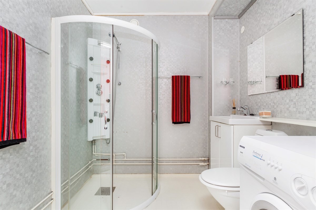 Romslig bad med massasjedusj og opplegg for vaskemaskin Galleribilde