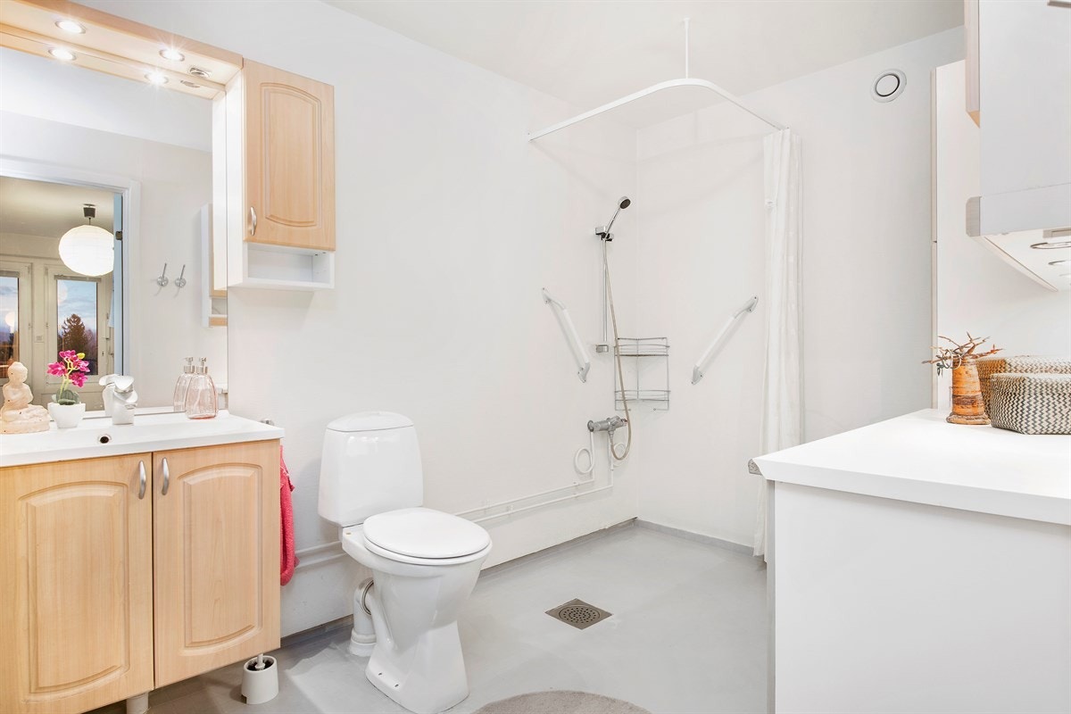 Romslig bad med lyst belegg på gulv og hvitmalte vegger Galleribilde