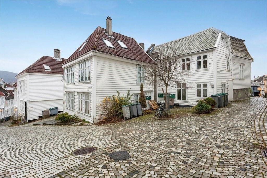 Brosteinsbelagt gatetun med eldre bebyggelse Galleribilde