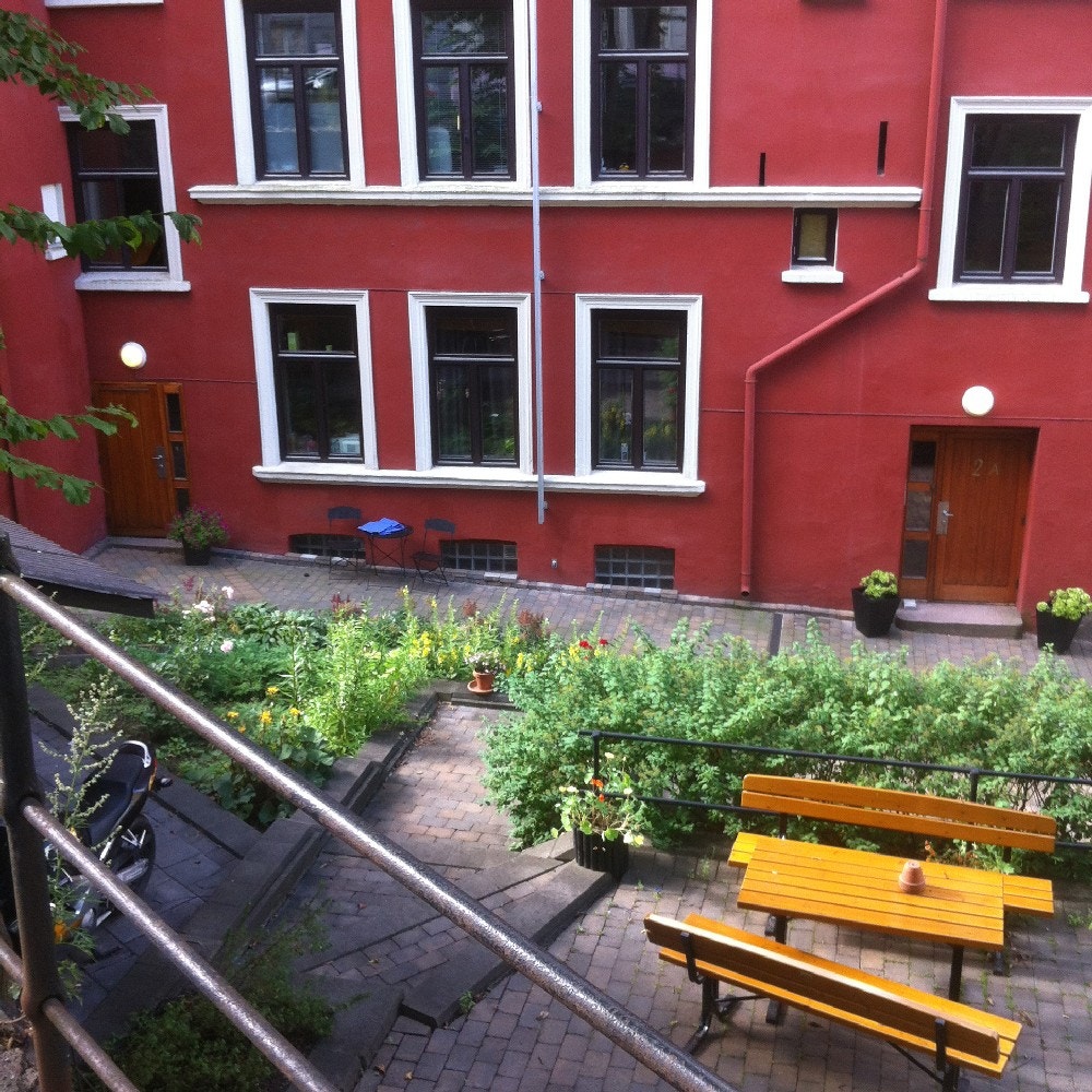 Koselig bakgård med beplantning og sitteplasser. Galleribilde
