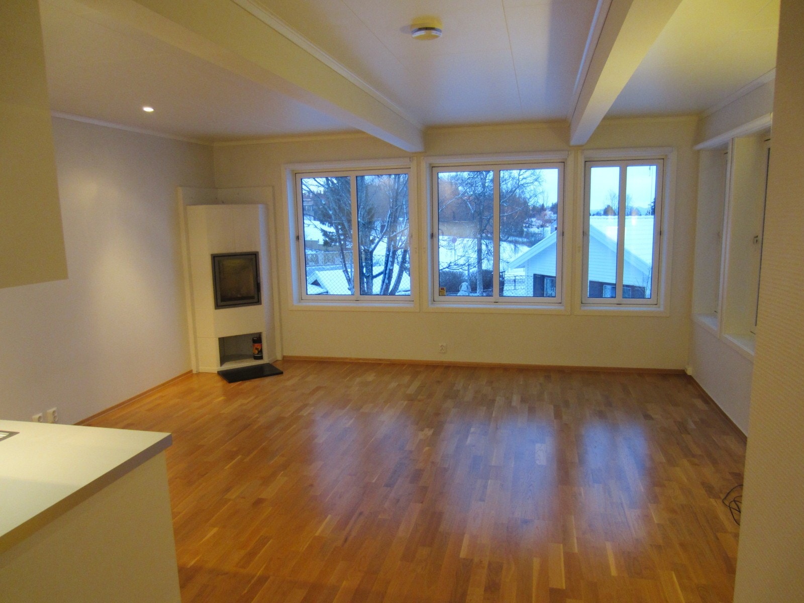 Stue med peisovn og store vinduer. Utsikt til Tyholttårnet og Forbordsfjellet. Galleribilde