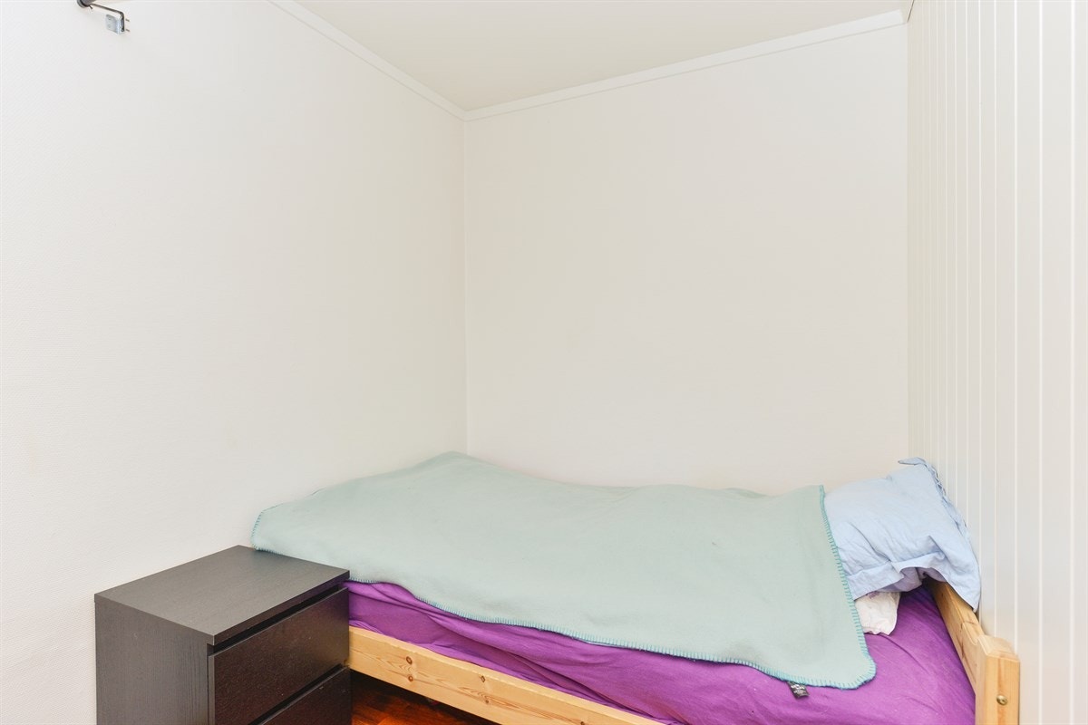 Sovealkove med åpen løsning mot stue. Mange av de andre leilighetene i blokka med lik størrelse har satt opp vegg mot stue med skråvegg mot gang. Galleribilde