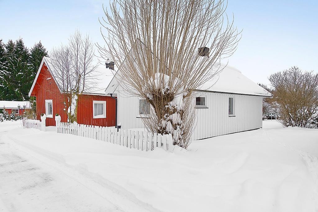 Fasade. Boligen har fast parkeringsplass mellom garasje og det hvite huset Galleribilde