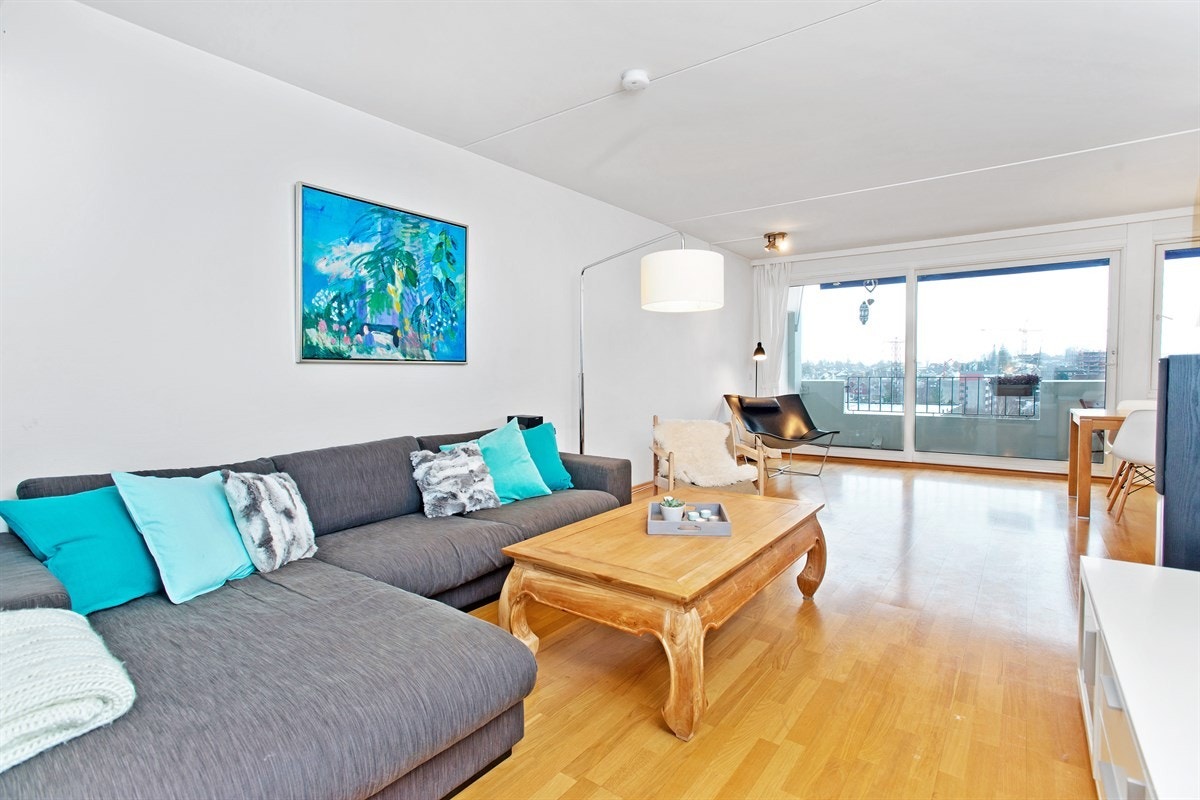 Lys og pen stue med store vindusflater mot balkong Galleribilde