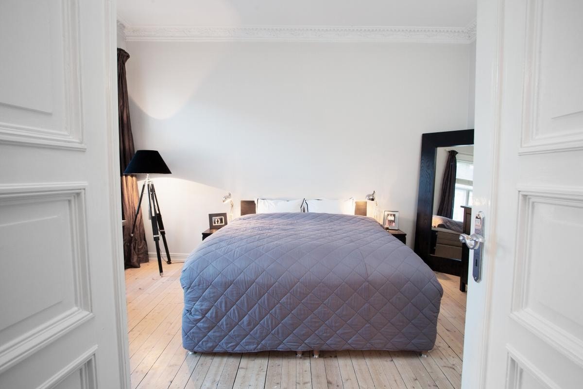 Dobbeltdører inn til klassisk soverom med stukkatur, rosett, samt pipeløp. Galleribilde