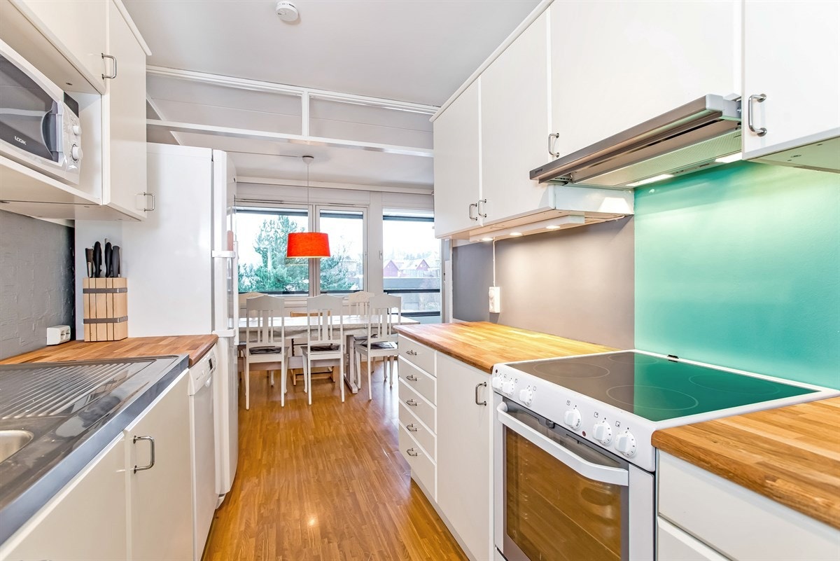 Lyst og praktisk kjøkken med hyggelig spiseplass Galleribilde