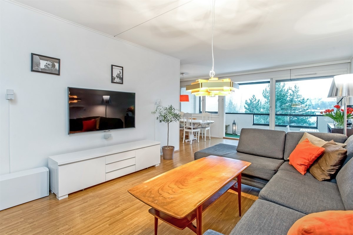 Lys og romslig stue med store vindusflater og skyvedør mot innglasset veranda Galleribilde