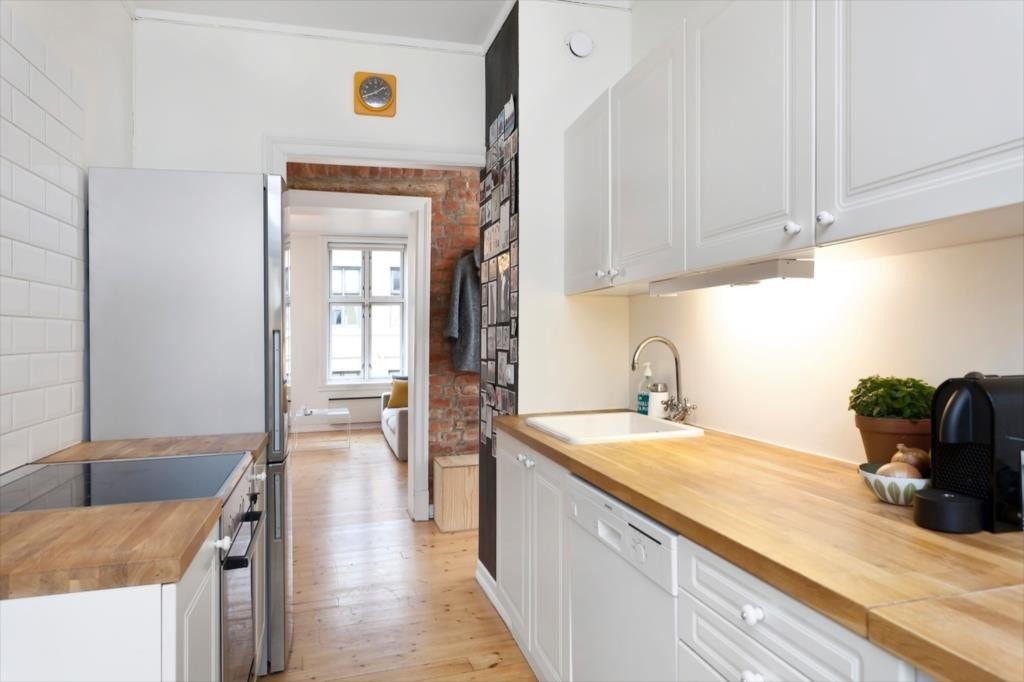 Hvit profilert kjøkkeninnredning. Opplegg for oppvaskemaskin. Plass for vaskemaskin. Galleribilde