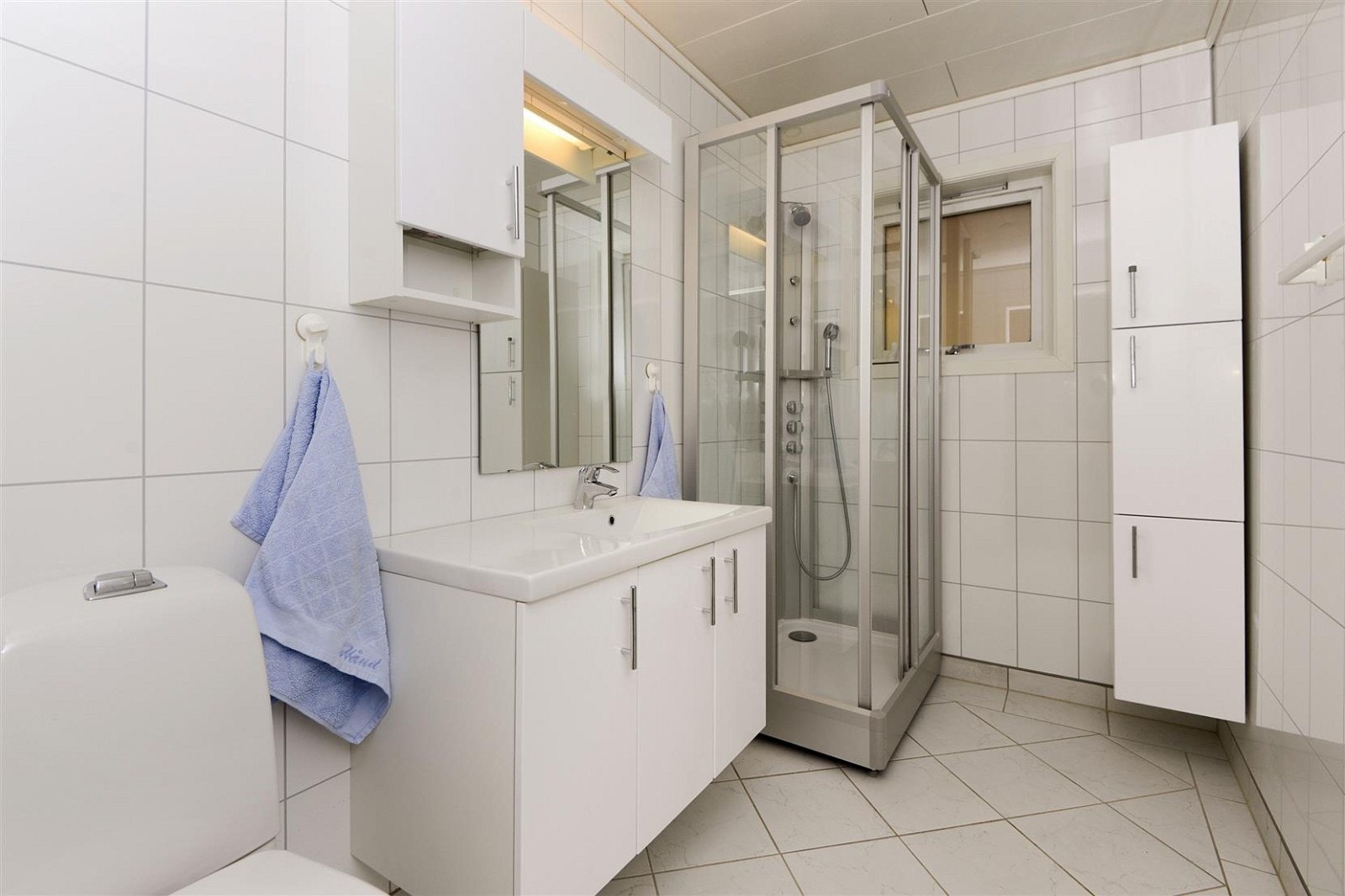 Bad er oppusset med fliser på gulv, lys innredning med god skapplass, varmekabler i gulv. Galleribilde