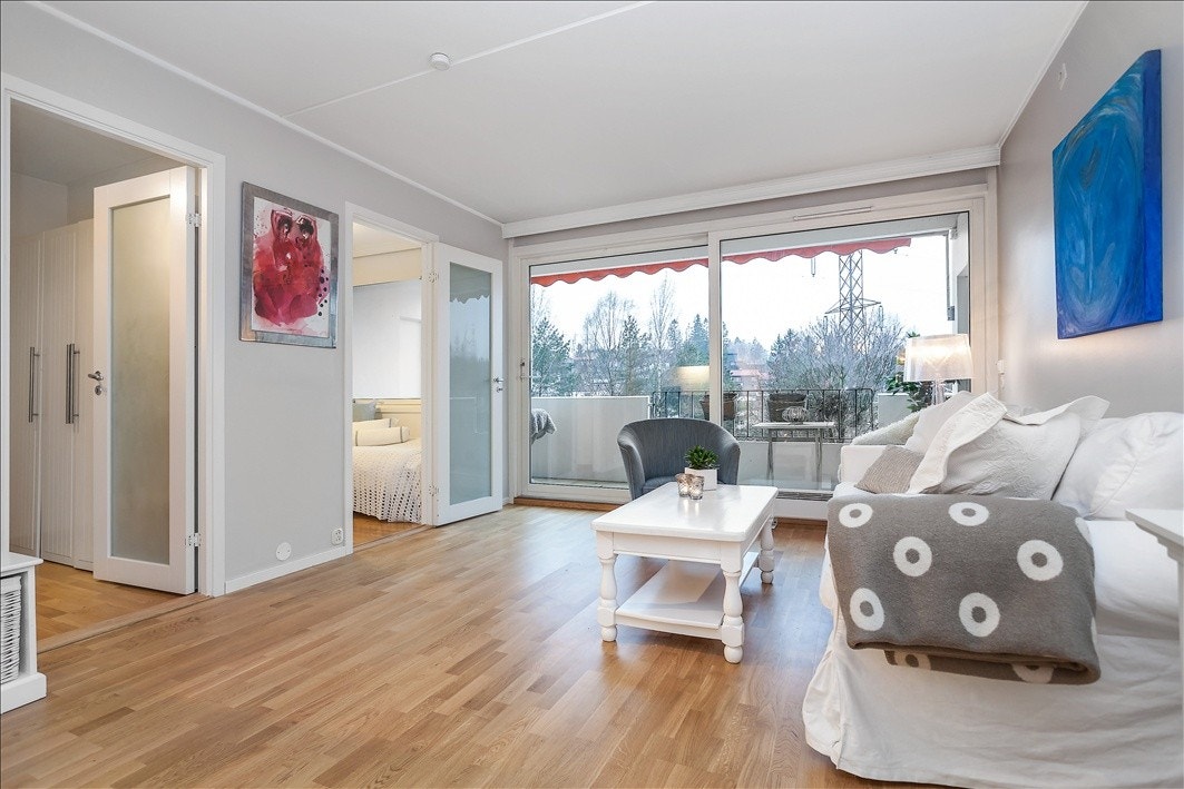 Lys og pen stue med stor skyvedør ut til veranda. Galleribilde