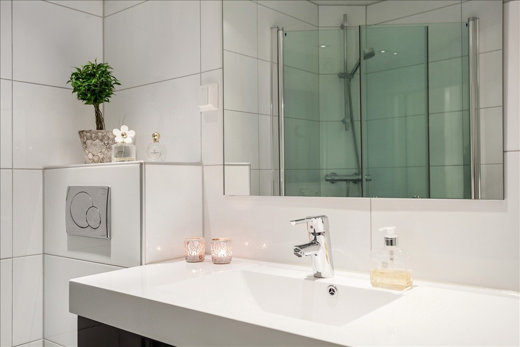 Badet har store flotte fliser og en stor bred servant Galleribilde