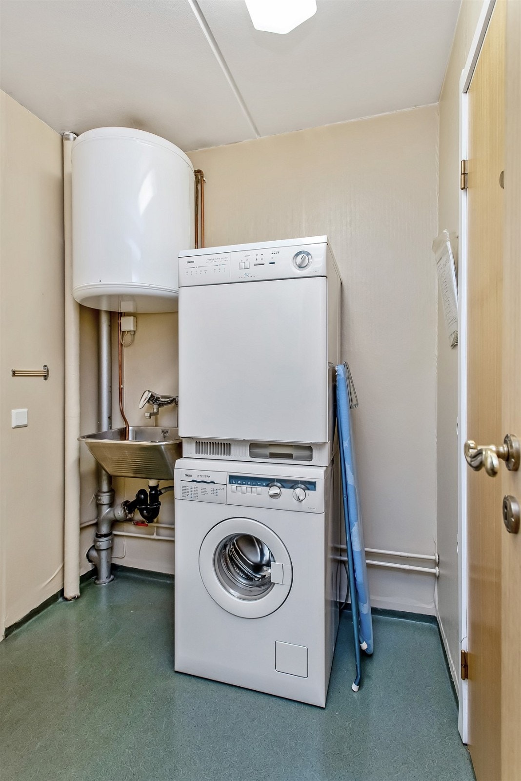 Vaskerom med utslagskum og opplegg for vaskemaskin/tørketrommel. Varmtvannstank over kum. Galleribilde