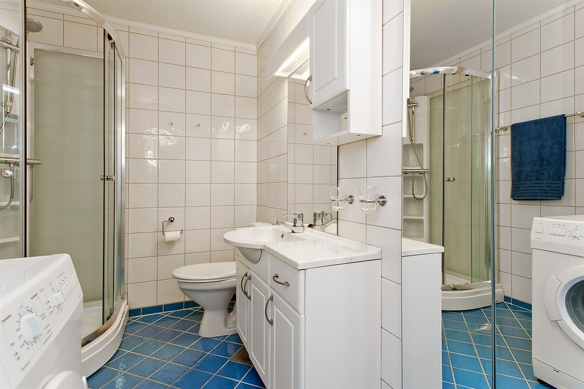 Pent, flislagt bad med dusjkabinett og opplegg for vaskemaskin Galleribilde