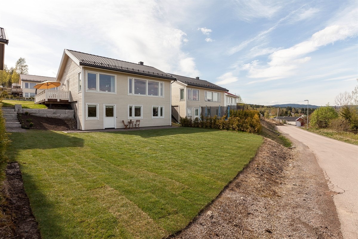 Baksiden av huset har en stor gressmatte. Galleribilde