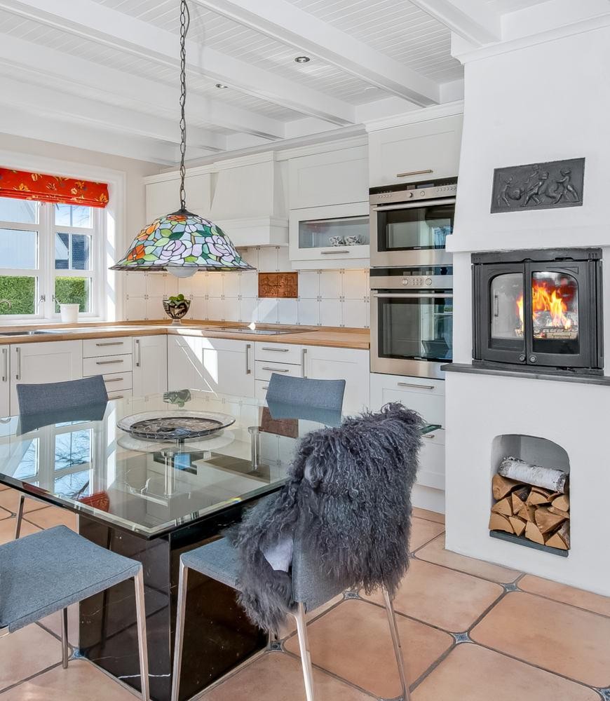 Lekkert kjøkken med peisovn. Galleribilde
