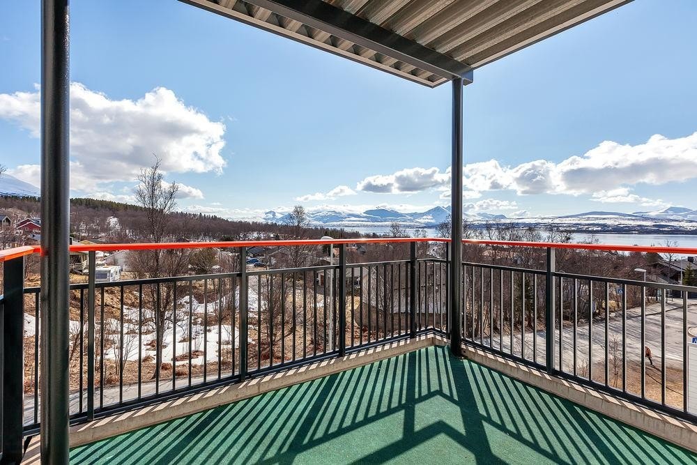 Flott veranda med spektakulær utsikt mot sør-vest. Her nyter man solen fra tidlig morgen til sen ettermiddag. Utsikten er mot Sør-Tromsøya, Malangsfjellene, Grindøya, Sundet og Kvaløya. Galleribilde