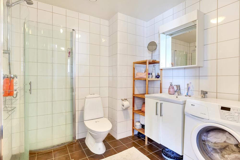 Stort bad for 2-roms å være. Pent flislagt med mørke kontrastfliser på gulv. Innfellbart dusjhjørne sparer mye plass. Galleribilde