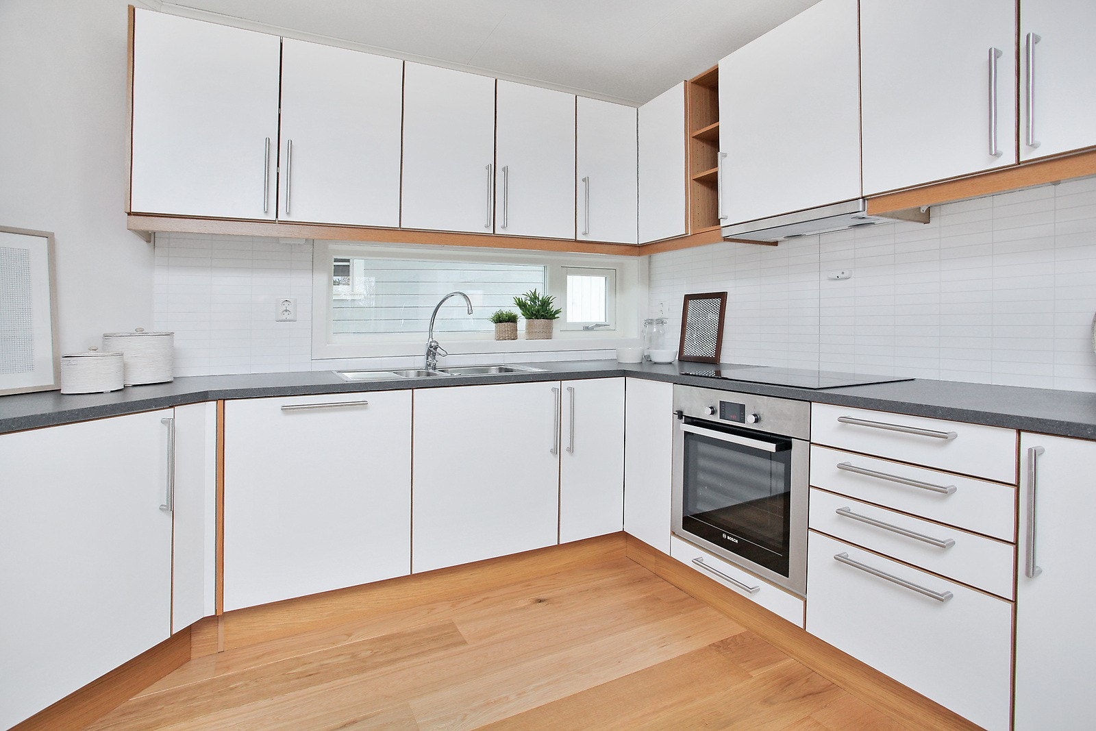 Flott kjøkken med integrerte hvitevarer - barløsning mot stue og spiseplass Galleribilde