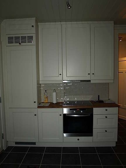 Del av kjøkken med integrert komfyr og kjøleskap Galleribilde