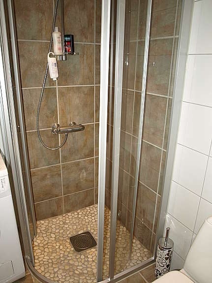 Nydelig høystandarddusj med rullesten på gulvet og fliser på vegg. Galleribilde